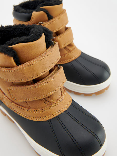 Pair of children's winter boots with black soles and brown straps on a white background