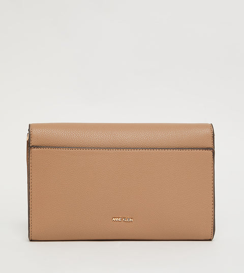 Tan clutch bag with 'Anne Klein' logo on a light gray background