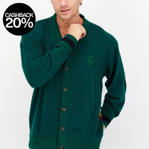 Man wearing a green cardigan with a logo on a white background