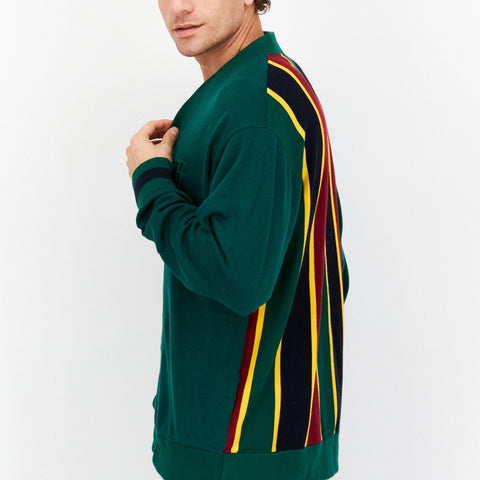 Man wearing a green sweater with colorful stripes on a white background