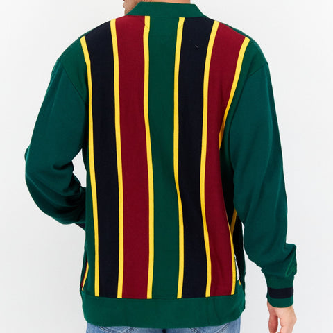 Person wearing a green sweater with red, yellow, and black striped pattern on a white background