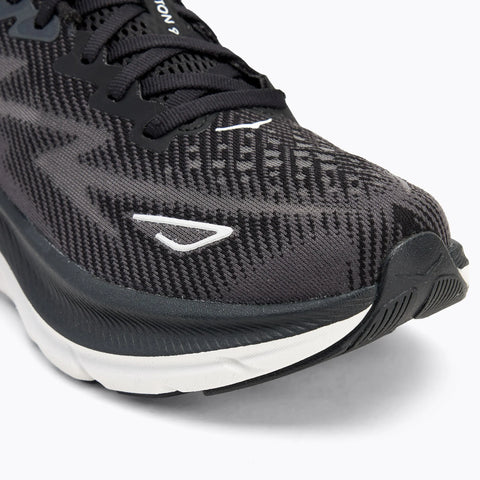 Black running shoe with white sole on a light gray background