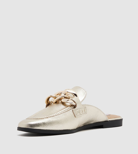 Gold loafer shoe on a light gray background