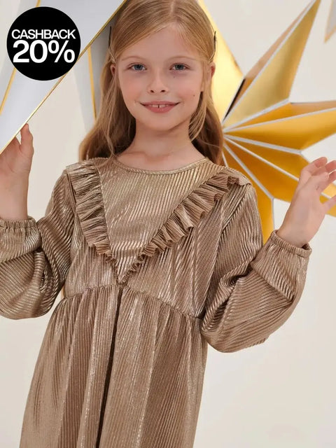 Young girl wearing a gold dress with ruffles against a white background