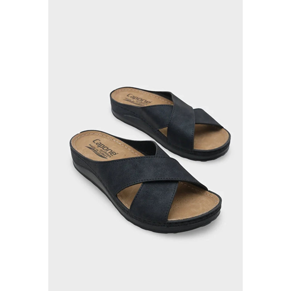 A pair of black wedge slide sandals with crisscrossing straps, shown on a light gray background. The brand name 'Caprioli' is visible on the tan insoles.