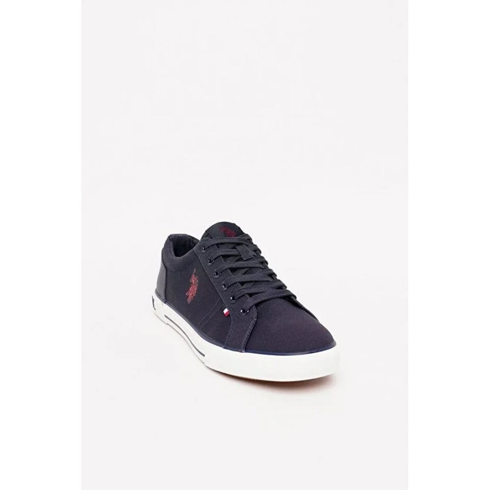 A single low-top sneaker in navy blue canvas with a white rubber sole, featuring a small red embroidered polo player logo on the side and tongue.