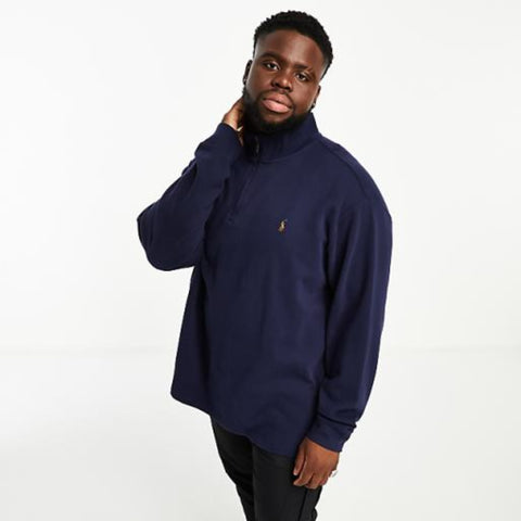 Man wearing a navy blue sweater and black pants on a white background