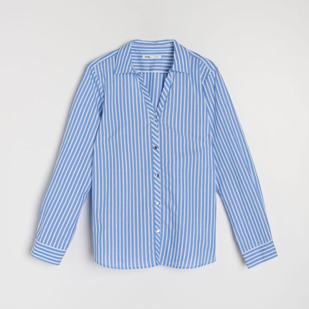 A long-sleeve button-up shirt with a blue and white vertical stripe pattern, laid flat against a light gray background.