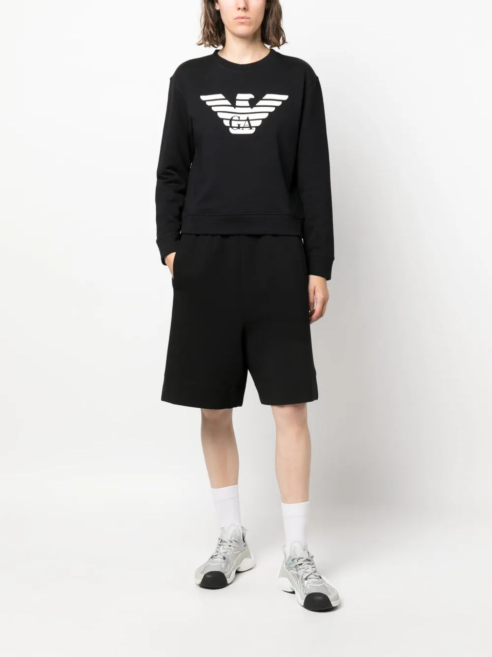 Person wearing a black outfit with a logo on a white background