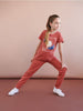Young girl wearing a red outfit with a graphic design on a beige background