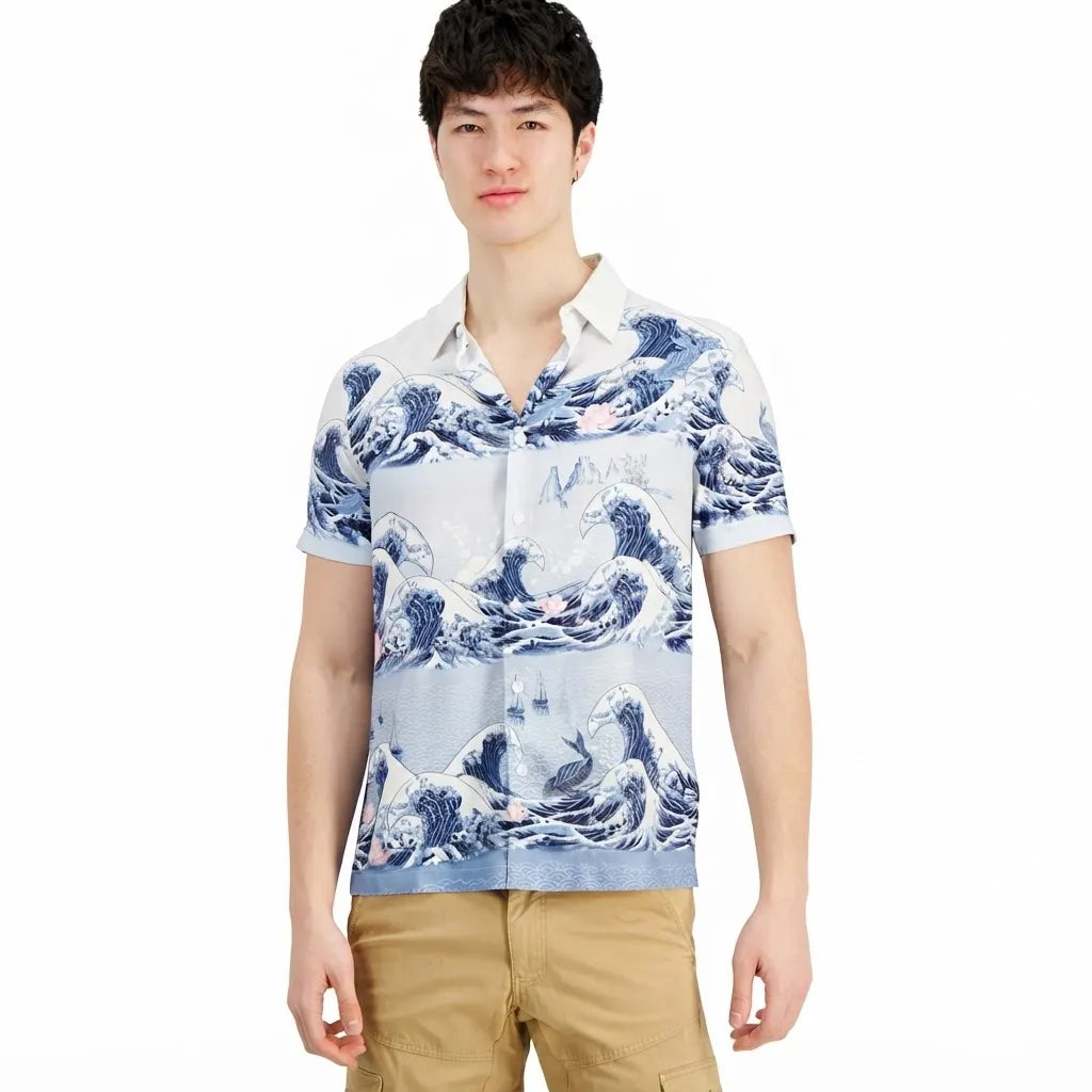 A man wearing a short-sleeve button-up shirt with a blue and white ocean wave print, paired with khaki pants, against a plain white background.