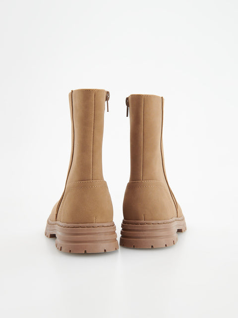 Pair of tan boots on a white background
