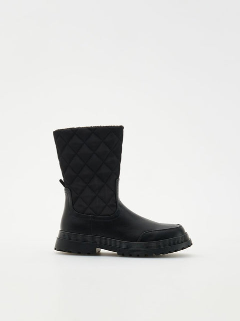 Black quilted boot on a white background