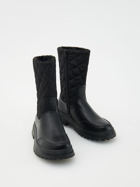Pair of black quilted boots on a light gray background
