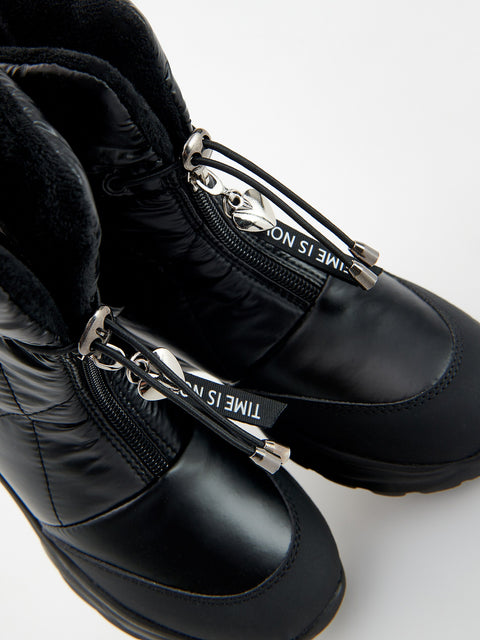 Black winter boots with silver zippers on a white background