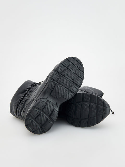 Pair of black winter boots on a light gray background