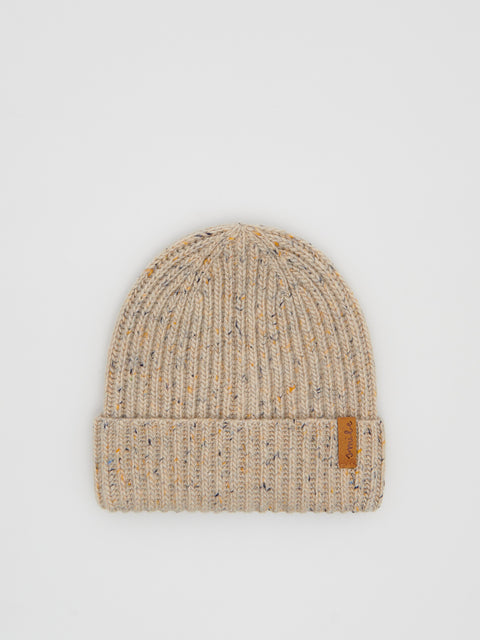 Beige knit beanie with a brown label on a light gray background