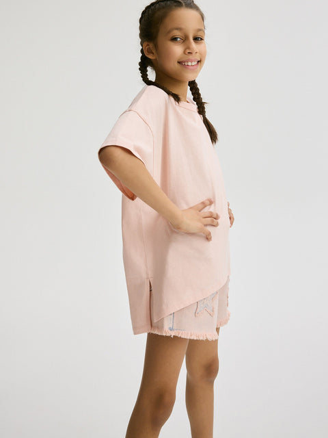 Young girl wearing a light pink dress against a white background
