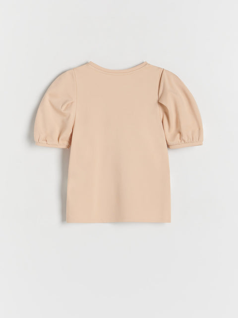 Beige top with puff sleeves on a light gray background