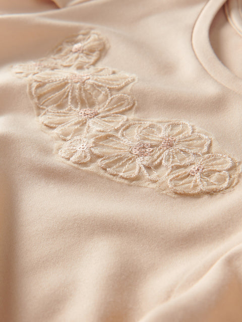 Close-up of a beige fabric with floral embroidery