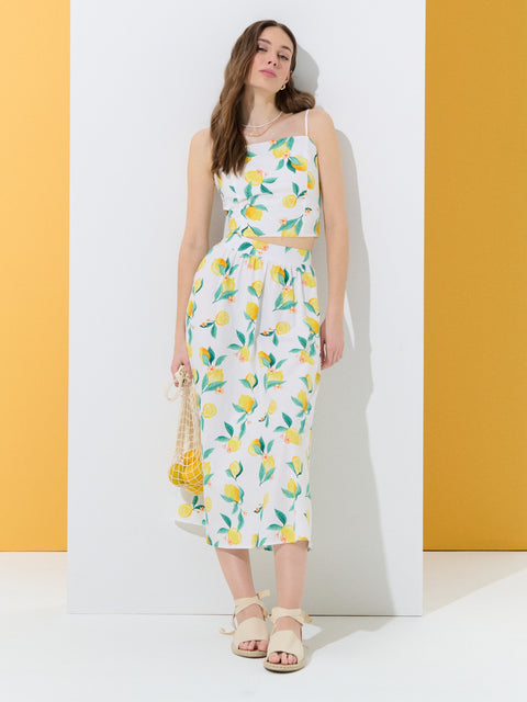 Woman wearing a floral dress with lemon pattern against a yellow and white background