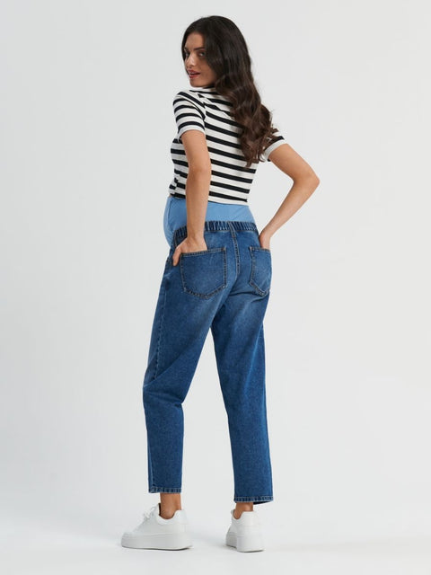 Woman wearing a black and white striped shirt and blue jeans on a white background