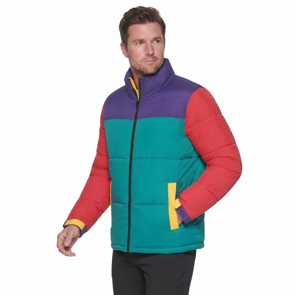 A man wearing a color-blocked puffer jacket with purple, teal, and red panels, yellow trim, and a black front zipper, photographed against a plain white background.