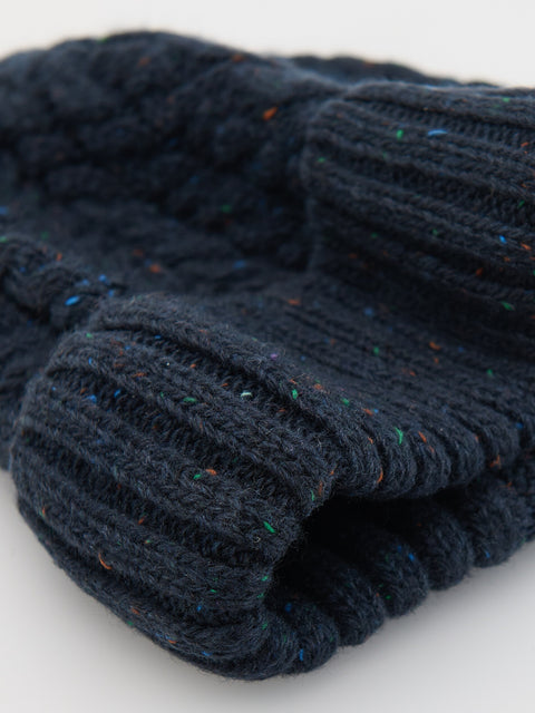 Folded navy blue knitted fabric on a light gray background