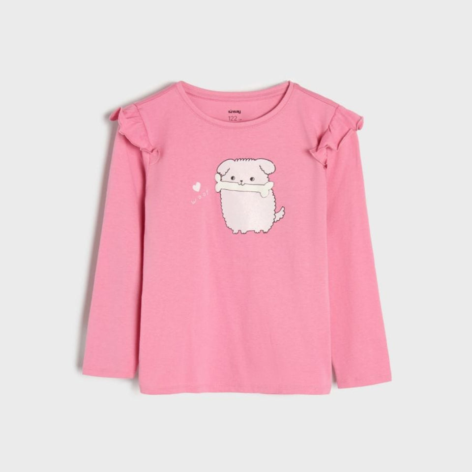 A pink long-sleeve children's top with ruffled shoulder details and a white cartoon dog graphic on the front, displayed against a light gray background.