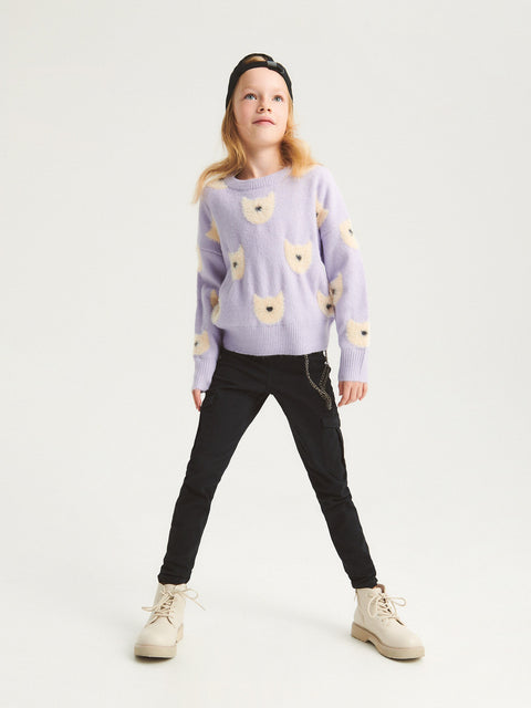 Person wearing a light purple sweater with bear patterns on a white background