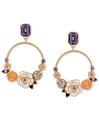 Pair of floral earrings with purple gemstones on a white background