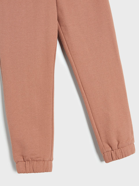Close-up of a pair of brown sweatpants on a white background
