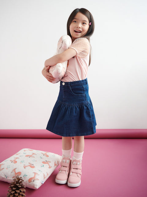Young girl holding a pink teddy bear against a white background