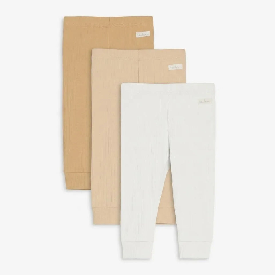 Three pairs of ribbed knit baby leggings in beige, tan, and white, arranged in a staggered stack on a light gray background.