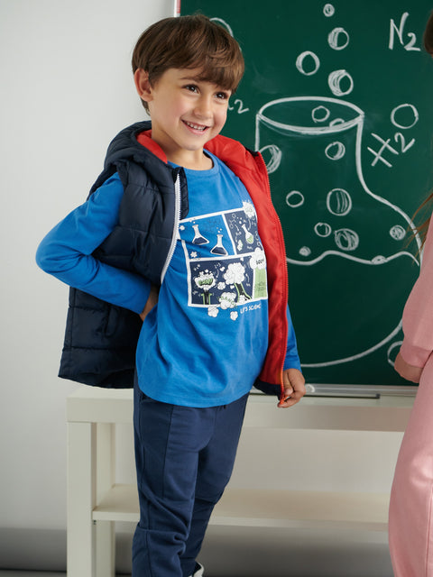 Child in a classroom setting with a chalkboard in the background
