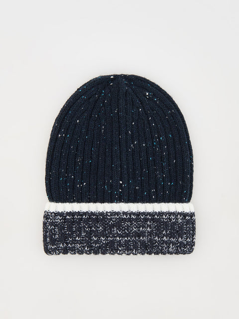 Black knit beanie with white speckled pattern on a light gray background