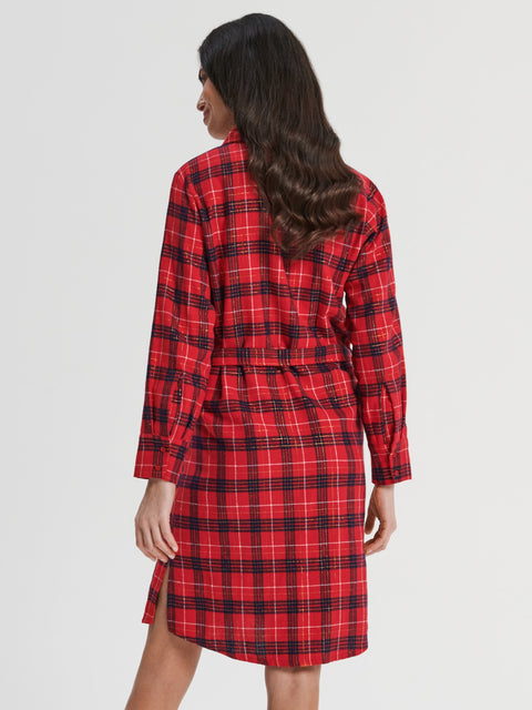 Woman wearing a red plaid dress against a white background