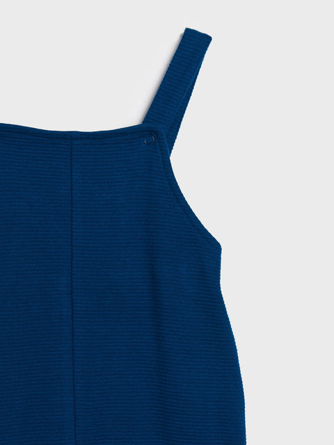 Blue ribbed dress with thin straps on a light gray background
