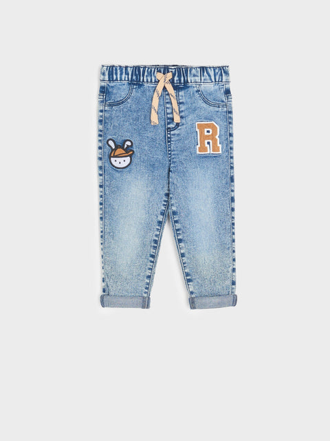 Children's blue jeans with patches on a white background