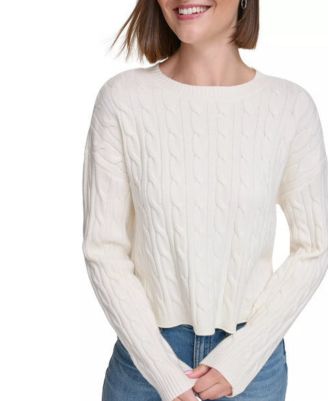 Woman wearing a cream cable knit sweater on a white background