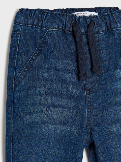 Close-up of blue denim pants with drawstring on a white background