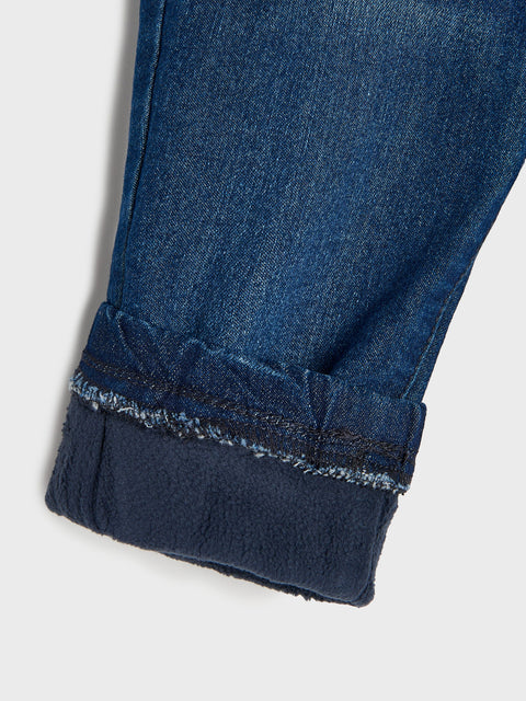 Close-up of blue jeans with rolled-up hem on a white background