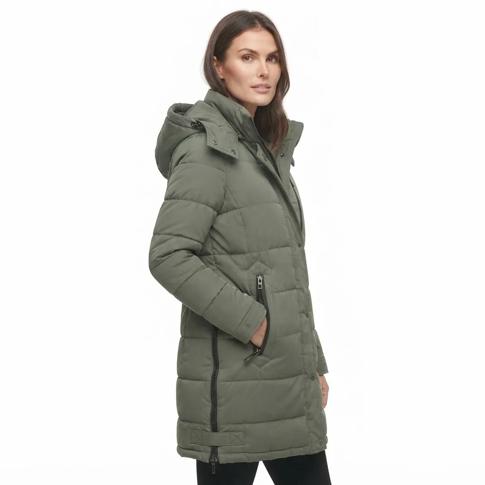 A woman wearing a mid-length olive green hooded puffer coat with black zipper details, shown in profile against a plain white background.