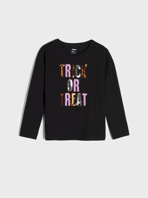 Black long-sleeve shirt with 'Trick or Treat' text in colorful letters on a light gray background