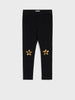 Black leggings with gold star designs on a white background