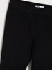 Close-up of black pants with a brand label on a white background