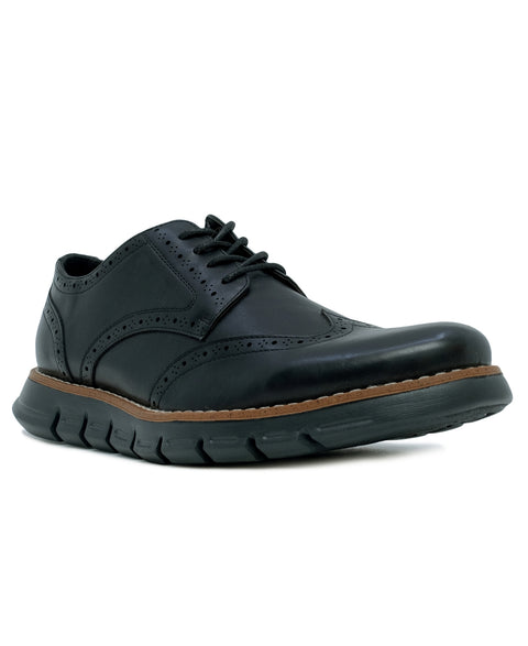 Black leather shoe with brown sole on a white background