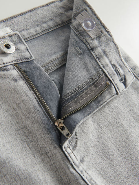 Close-up of gray denim jeans with zipper and button details.