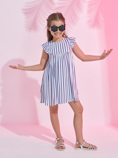 Young girl wearing a striped dress and sunglasses on a pink background