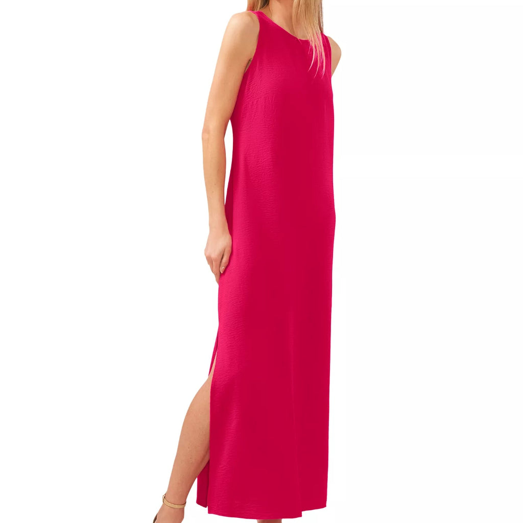 A woman modeling a sleeveless, bright pink maxi dress with a high side slit, paired with nude high-heeled sandals, against a plain white background.
